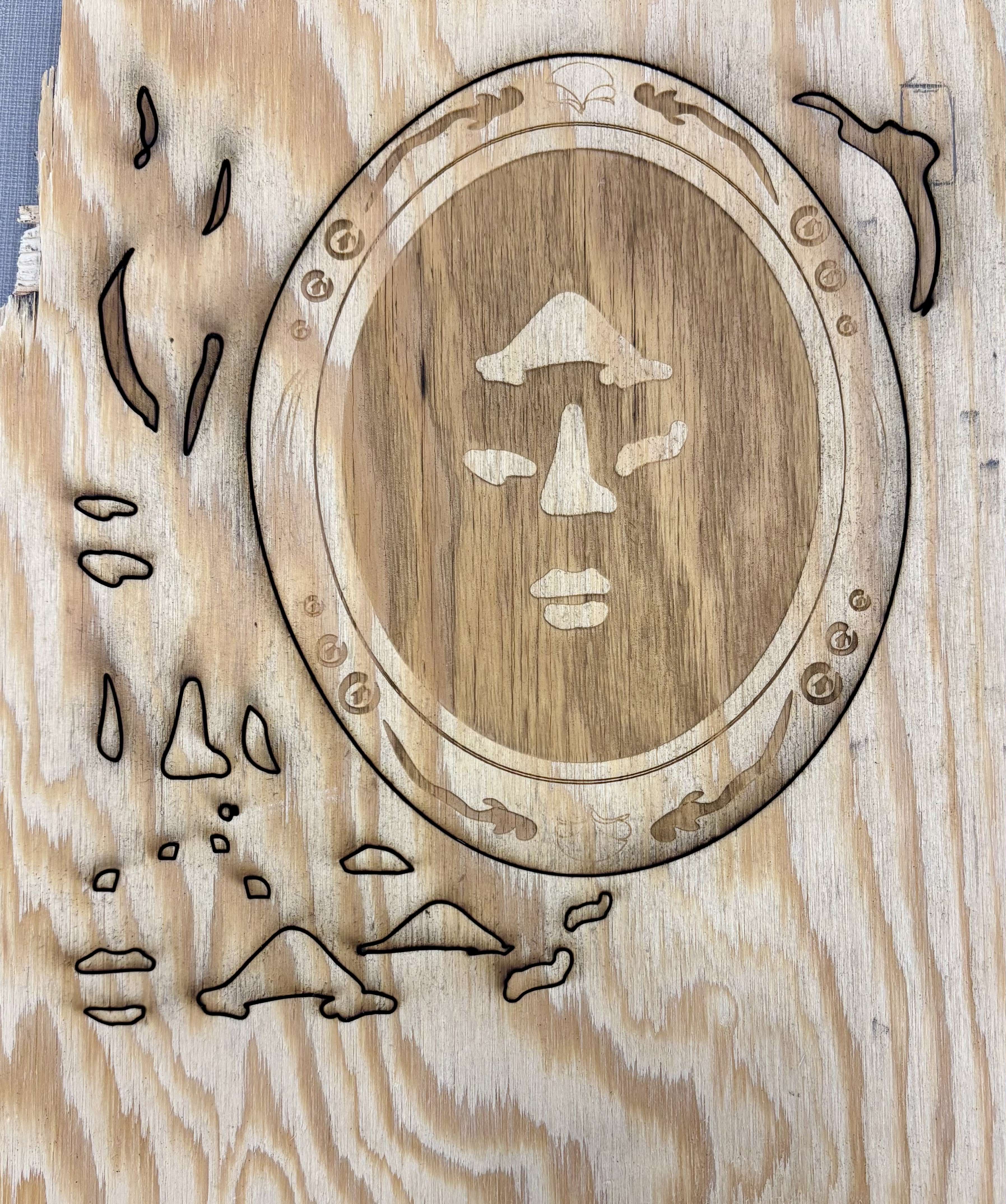 piece of wood with the face and surrounding 3D pieces engraved onto it